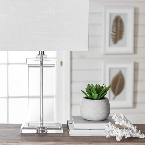 Toledo 25 Inch Crystal Table Lamp With Cotton Shade on side table next to potted plant and decorative objects in living room.