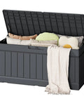 80 Gallon Resin Outdoor Storage Box With Wood Texture Waterproof Deck Box For Patio Cushions And Outdoor Gear No Fuss All Weather Storage Bin Grey That Stays Dry filled with cushions and a blanket, open lid view.