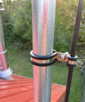Close-up of Six Pack P Clamps Rubber Insulated Clips for UTV Windshield Wires 44mm Diameter mounted on a metal pipe outdoors