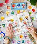 Person decorating journal with 50 Piece Hot Air Balloon Sticker Pack For Teens And Creative Vibes Waterproof Vinyl Balloons Stickers Set For Laptops Journaling Water Bottles Notebooks Classrooms And Dope DIY Decor.