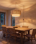 18 Inch Plug In Rattan Pendant Light With Premium Linen Shade Boho Ceiling Chandelier over rustic wooden dining table.