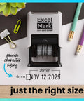 Straight Up Knockout Date Stamp For Shipping And Receiving Orders Track Expiration And Due Dates Smooth Gliding Mechanism Crisp Black Ink On Durable Gray Mount on a desk with office supplies.