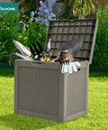 32 Gallon Rattan Deck Box With Lockable Lid And Side Handles, filled with garden tools, on green grass, weatherproof resin, brown