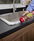 Flex Caulk 9 oz white hybrid polymer sealant being applied along a kitchen sink edge.
