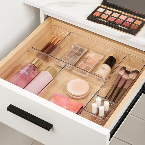 Level Up Your Vanity Game With This 10 Piece Clear Drawer Organizer Set, featuring clear bins holding cosmetics and brushes in a tidy drawer.