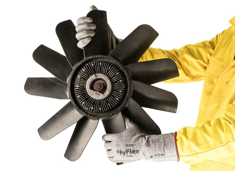 Person wearing Cut Protection Gloves With Intercept Yarn ANSI A2 For Sharp Objects And Debris holds large black industrial fan blade.