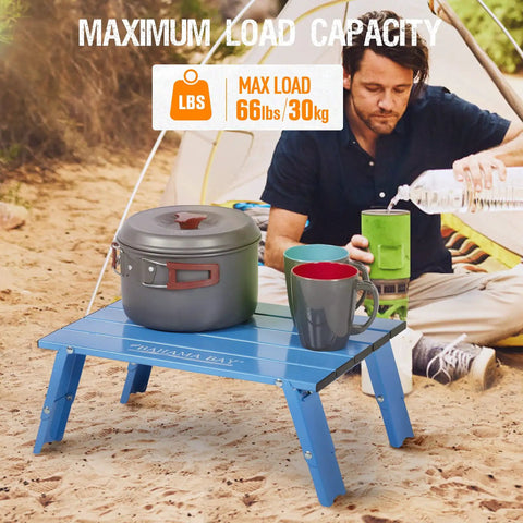 Ultralight Aluminum Mini Table With Adjustable Retractable Legs, 66 Lb Capacity, shown in use outdoors with camping gear.