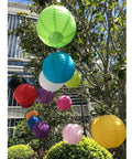 Colorful paper lanterns hanging in a garden, showcasing Six Inch White Paper Lanterns Set Of Six Hanging Round Lanterns For Birthday Party Wedding Christmas Bridal Home Decor Chinese Japanese Style Easy To Hang And Reusable.