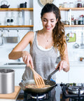 Woman cooking in kitchen near Stainless Steel Jumbo Grease Container With Removable Strainer And Snug Lid For Fryer Oil Bacon Drippings