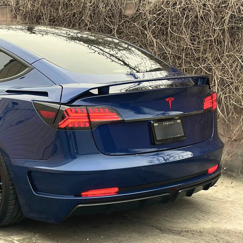 Knight Rider Led Tail Light Upgrade Kit For Model 3 And Model Y Plug And Play Rear Lamps In Flame Design illuminating a blue Tesla Model 3 rear.