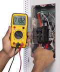 Person using Dm6410 8 Function Digital Multimeter With Large LCD Display And Data Hold For Accurate AC DC Voltage And Current Measurements Yellow Pro Grade Tool For Electricians on electrical panel.