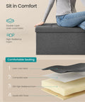 Woman sitting on Mazie Collection 43 Inch Folding Storage Ottoman Bench With Quick Foldaway End Of Bed Foot Rest And Underbed Storage Go-To For Living Room Bedroom Or Entryway Dark Gray showing seat layers.