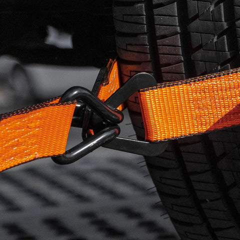 Beefy Pro Series 2 Inch Ratchet Strap With Wire Hooks securing around a tire, optic orange webbing visible, rugged hauling use