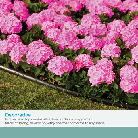 Pro Grade Landscape Edging Coil With Double Ridge Design For Flexible Sixty-Foot Roll For Gardens, Flower Beds, And Pathways Black Finish Made In The USA creating a clean border around pink flowers.