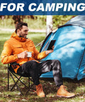 Man sitting on Two Pack Ultra Lightweight Camping Chairs For Adults And Teens, 250 Lb Capacity, in front of a blue tent.