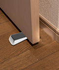 Heavy Duty Door Stop Wedge Stopper 2-Pack For Home, Office, And Apartment Safety under a wooden door on hardwood floor