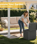 Woman placing cushion in Big 31 Gallon Outdoor Storage Box With Lid For Patio Furniture, Garden Tools, And Pool Supplies, Weatherproof, UV Resistant, Lockable, Dark Grey, Heavy Duty Outdoor Organizer.