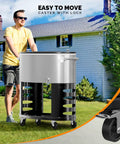 Man pushing 70 Qt Rolling Patio Cooler On Wheels With Bottle Opener and Ice Scoop, outdoor scene next to house, close-up of wheels