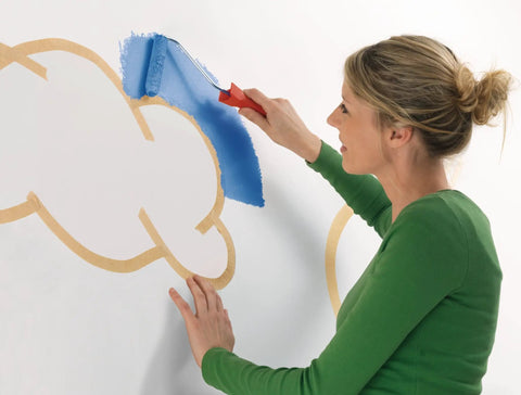 Woman painting with blue paint using Masking Tape For Curves Ultra Flexible 19mm By 25m Pro Grade Tape on a wall.