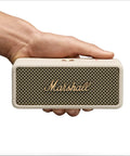 Hand holding Emberton III Portable Bluetooth Speaker With Rugged Waterproof Build And Dust Proof Design Loud Stereo Sound And Deep Bass For Travel Outdoors And Everyday Use Compact Wireless Cream, front view