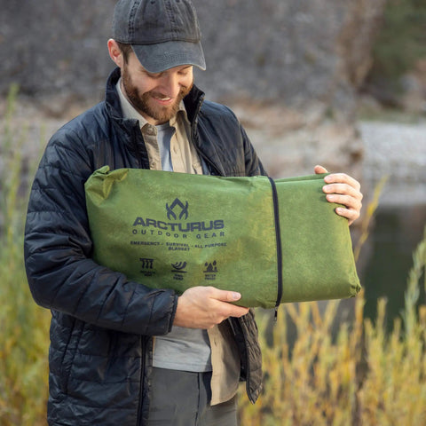 Man holding Tough As Nails Heavy Duty Survival Blanket With Reflective Thermal Layer For Camping And Outdoor Gear Waterproof