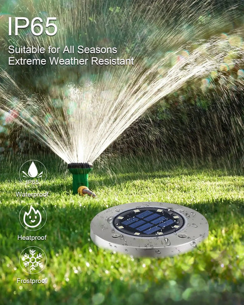 12 Pack Solar Ground Lights For Outdoor Use Waterproof Disk LED Lights on lawn with active sprinkler in background