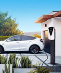Slick Level Two EV Charger With J1772 Connector Delivering A Steady 32 Amp Output At 240 Volts Includes A 25 Foot Cable Plus Nema 14 50 Adaptor outside a garage next to a white electric vehicle.