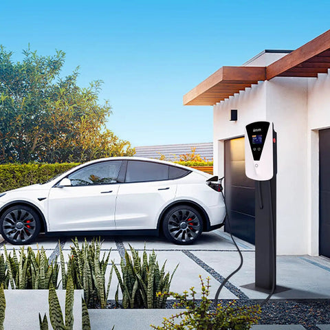 Slick Level Two EV Charger With J1772 Connector Delivering A Steady 32 Amp Output At 240 Volts Includes A 25 Foot Cable Plus Nema 14 50 Adaptor outside a garage next to a white electric vehicle.