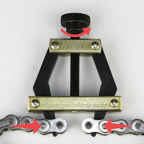 Roller chain breaker tool with adjustable screw, black frame and visible bicycle chain links