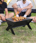 Outdoor scene with Portable Campfire Grill For Outdoors Large Folding Stainless Steel Fire Pit With Grill And Carry Bag Heavy Duty Charcoal BBQ.