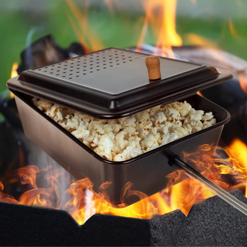 Campfire Popcorn Popper for Open Flame Cooking with Nonstick Finish and Extended Handle, filled with popcorn over a fire.