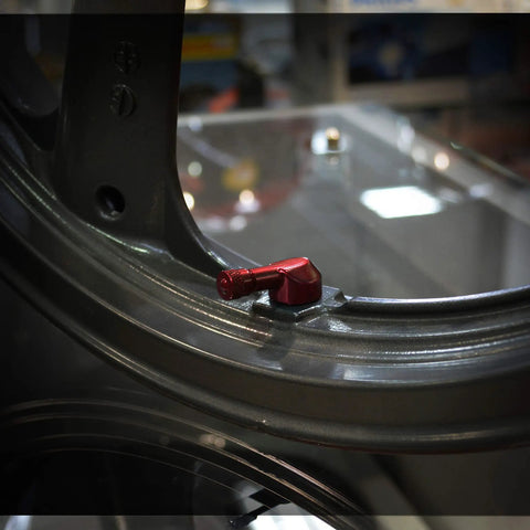Forged Alloy Angled Valve Stem With Pre Applied Threadlocker Nut 0.357in Size Red installed on a standard rim opening