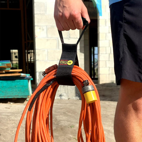 Person holding orange extension cord using Assorted Three Pack Heavy Duty Easy Carry Straps With Built In Handle For Garden Hose