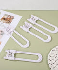 Five Adjustable U Shaped Childproof Cabinet Locks 15 Pack No Tools Needed Easy Install ABS Material on green surface.