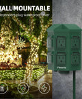 Outdoor Power Stake With A 50 Foot Waterproof Extension Cord Remote Controlled Three Separate Outlet Groups And Six Grounded Outlets For Backyard Garden Patio And Outdoor Decor ETL Listed, wall-mounted with holiday lights in background.