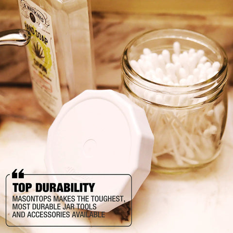 Tough Tops Regular Mouth Mason Jar Lids White BPA Free Plastic Screw Caps next to a jar filled with cotton swabs.