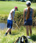Man using 18 Foot Telescopic Golf Ball Retriever With Lightweight Aluminum Shaft Stainless Cup And Locking Hinged Design For Easy Water Pond Mud And Rough Retrieval No Fuss Pickups Every Time beside a pond on a golf course.