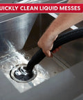 Hand using a hose from Premium 5 Gallon Wet Dry Shop Vac With Badass 135 Air Watt Suction to clean liquid messes in a stainless steel sink.