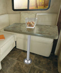 SurFit 27 Inch RV Table Leg System with silver aluminum base and fixed steel leg in RV setup with seating and window view