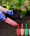 Gardener using pink shovel from 20 Pack Mini Colorful Metal Hand Shovels And Trowels Set For Transplanting And Garden Digging outdoors