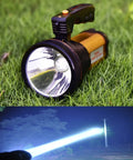 Beast Bright Handheld LED Spotlight Torch With USB Rechargeable Battery Long Throw Searchlight on grass and in use at night.