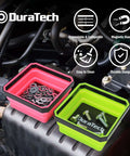 Two collapsible silicone tool trays with double-sided magnetic base holding screws and washers on a car engine