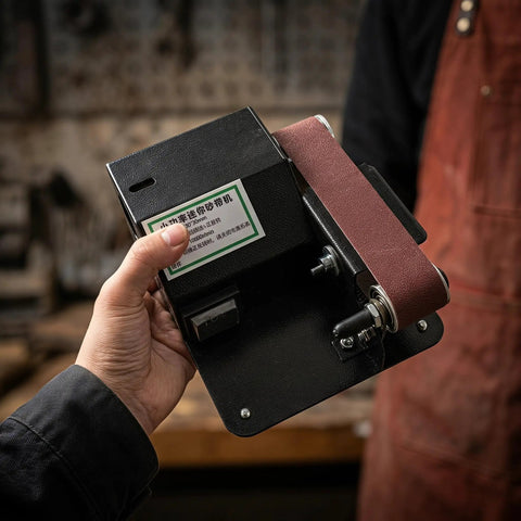 Compact Mini Electric Belt Sander With A Kickass Motor For Handheld Wood Sanding And Fast Metal Polishing Quick Rust Removal And Smooth DIY Finishes Built Like A Rock Solid Workhorse held in hand.