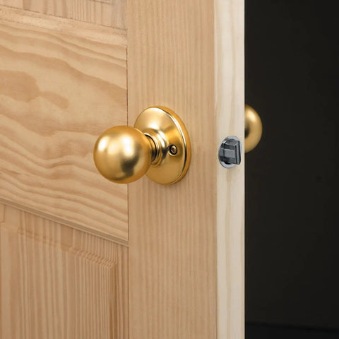 Close-up of a golden door knob on a wooden door, showing installation using Door Lock Installation Kit With C Clamp Design Hole Saw For Metal Or Wood Doors 2 Adjustable Bushings Tool Free Clamping Easy Height Alignment Accurate Drilling Pro Grade And User Friendly.