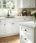 Matte Black Round Euro Style Cabinet Knobs One And One Quarter Inch 30 Pack on white kitchen drawers and island