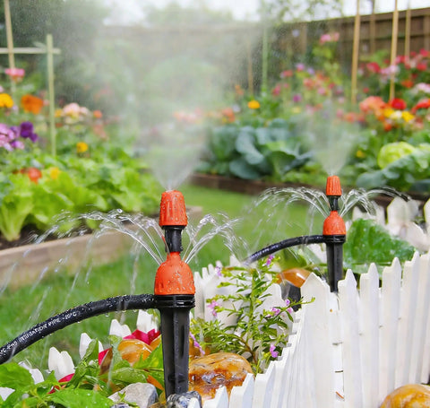 25 Adjustable Drip Irrigation Emitters For Quarter Inch Hose 360 Degree Water Flow Stake Drippers in a garden bed