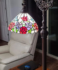 Tiffany Inspired Arched Stained Glass Floor Lamp 62 Inches Tall With rose pattern shade in cozy living room next to chair and table.