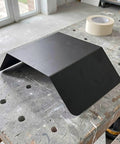 Heavy Duty Aluminum Wall Mount EV Charging Station Rain Shield Weatherproof Canopy on a workbench, showcasing black finish.
