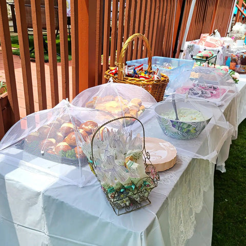 Outdoor buffet table with Inflatable Serving Bar And Mesh Food Covers Combo Set with 6 mesh tents protecting food at a party.