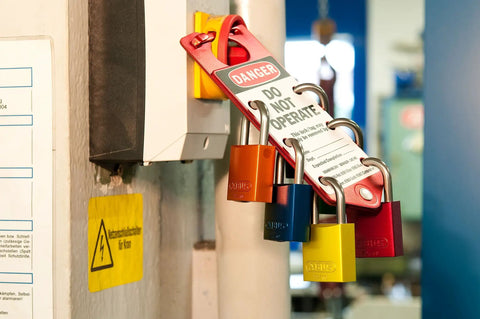 Orange Lockout Tagout Padlock Set With 1.5 Inch Shackle 12 Pack Keyed Alike in use on industrial equipment for safety.